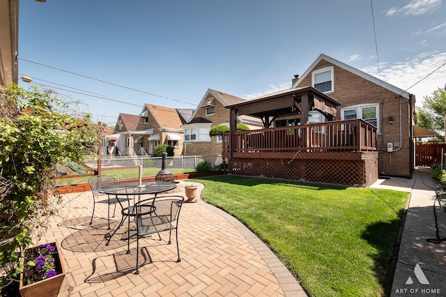 rear view of house with a deck, a patio, and brick siding