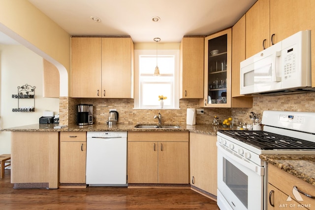 kitchen with white appliances, a sink, stone countertops, and decorative backsplash