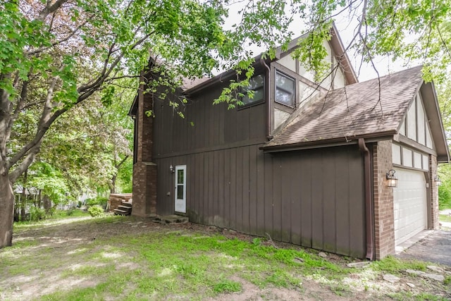 5N683 Ravine Dr, Saint Charles, IL 60175 - view of property exterior featuring a shingled roof, a garage, a chimney, and brick siding