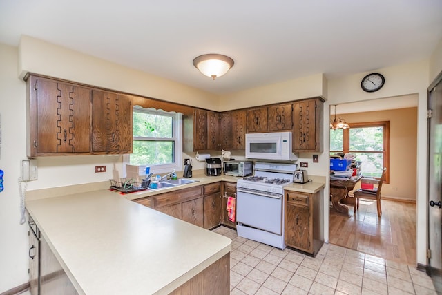 5N683 Ravine Dr, Saint Charles, IL 60175 - kitchen featuring white appliances, light countertops, a sink, and a peninsula