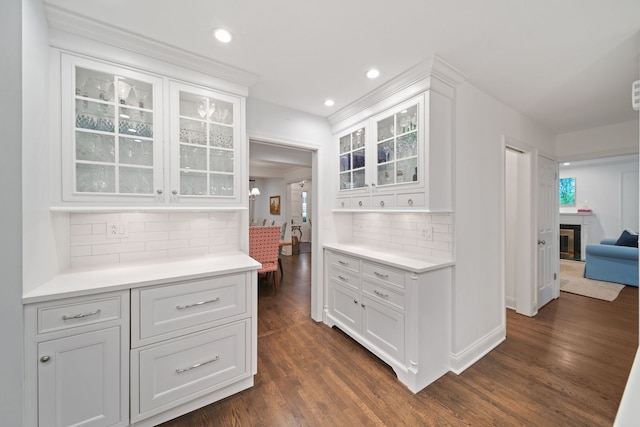 1305 Sleepy Hollow Rd, Glenview, IL 60025 - kitchen with a glass covered fireplace, dark wood-type flooring, light countertops, glass insert cabinets, and recessed lighting