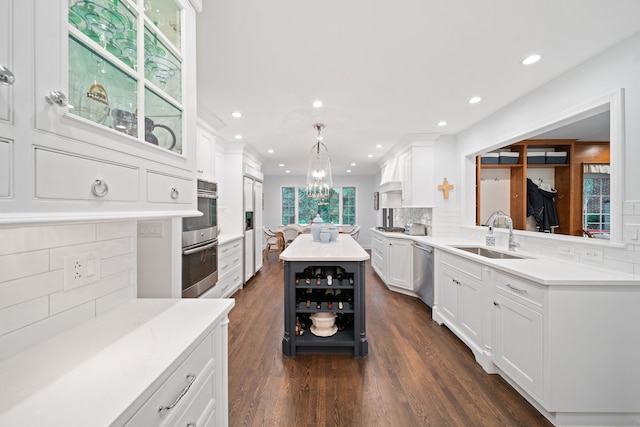 1305 Sleepy Hollow Rd, Glenview, IL 60025 - kitchen featuring a sink, appliances with stainless steel finishes, white cabinets, tasteful backsplash, and a kitchen island