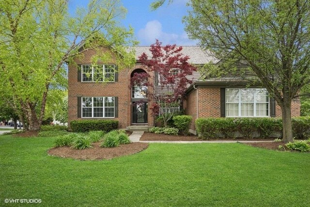 218 Bridle Path Ln, Fox River Grove, IL 60021 - traditional-style house featuring a front yard and brick siding