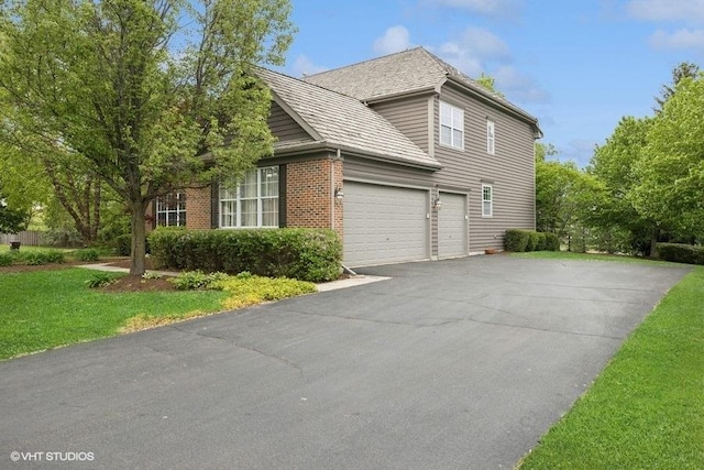 218 Bridle Path Ln, Fox River Grove, IL 60021 - view of home's exterior with asphalt driveway, brick siding, a garage, and a yard