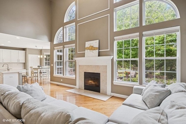218 Bridle Path Ln, Fox River Grove, IL 60021 - living area with a high ceiling, light wood-type flooring, baseboards, and a tile fireplace