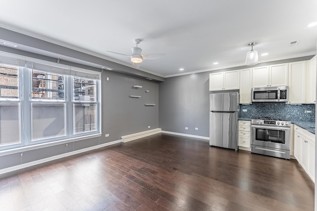 kitchen with appliances with stainless steel finishes, crown molding, backsplash, a ceiling fan, and white cabinets
