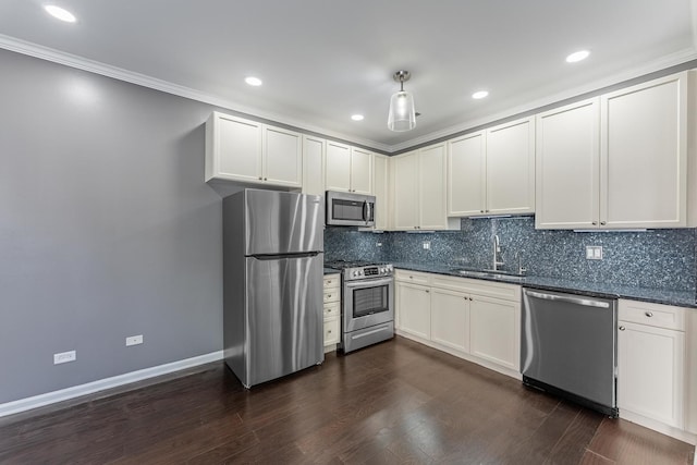 kitchen with appliances with stainless steel finishes, a sink, decorative backsplash, recessed lighting, and ornamental molding