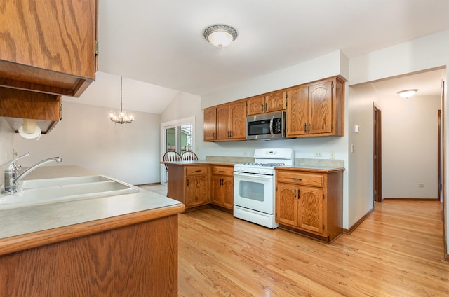 1936 Sybil Dr, Crest Hill, IL 60403 - kitchen featuring white gas range oven, stainless steel microwave, a sink, a peninsula, and brown cabinets