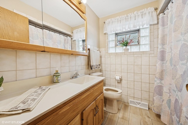 769 N Eastland St, Elmhurst, IL 60126 - bathroom featuring tile walls, toilet, vanity, wood finished floors, and curtained shower