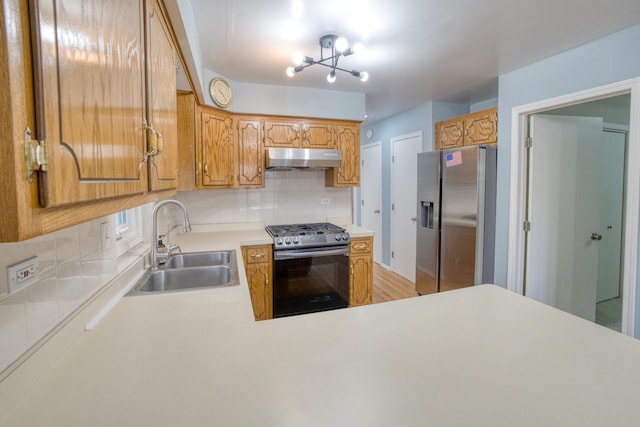 5416 N Neva Ave, Chicago, IL 60656 - kitchen featuring stainless steel appliances, a sink, under cabinet range hood, decorative backsplash, and light countertops