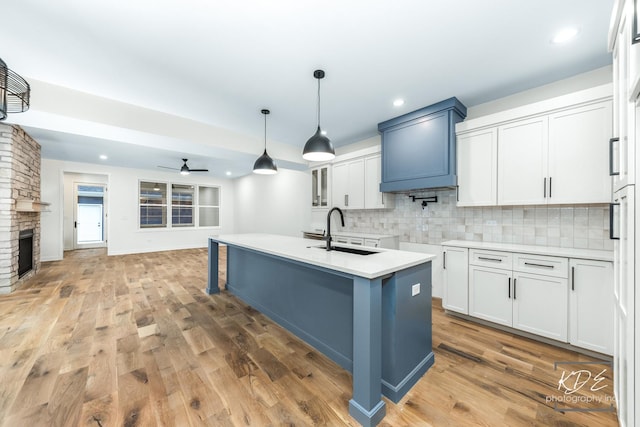 715 N Brainard St, Naperville, IL 60563 - kitchen featuring a ceiling fan, tasteful backsplash, light wood finished floors, light countertops, and an island with sink