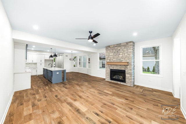 715 N Brainard St, Naperville, IL 60563 - unfurnished living room with a ceiling fan, light wood finished floors, a stone fireplace, and recessed lighting