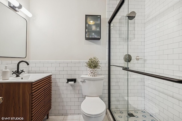 5415 N Sheridan Rd Unit 5011, Chicago, IL 60640 - bathroom featuring vanity, a stall shower, toilet, a wainscoted wall, and tile walls
