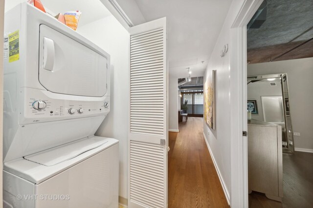 240 E Illinois St Unit 402, Chicago, IL 60611 - washroom with stacked washing machine and dryer, wood finished floors, and baseboards