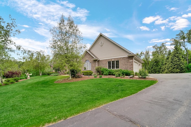 4916 Country Springs Dr, Johnsburg, IL 60051 - traditional home featuring asphalt driveway, a front yard, a garage, and brick siding