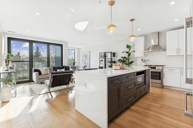 2212 W Lawrence Ave Unit 2W, Chicago, IL 60625 - kitchen with wall chimney range hood, electric stove, built in microwave, white cabinetry, and light wood finished floors