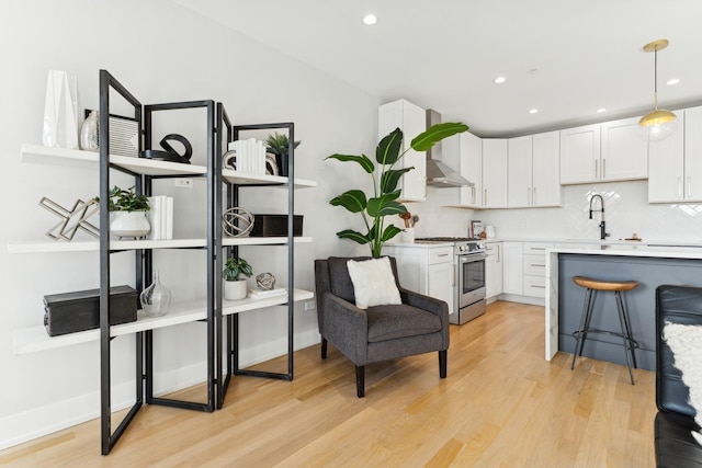 2212 W Lawrence Ave Unit 2W, Chicago, IL 60625 - kitchen featuring stainless steel range, a sink, light countertops, light wood finished floors, and tasteful backsplash