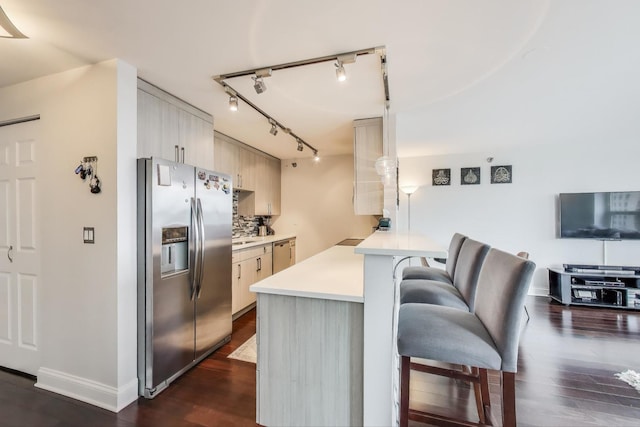 345 N Lasalle Blvd Unit 3602, Chicago, IL 60654 - kitchen with appliances with stainless steel finishes, a peninsula, a breakfast bar area, light countertops, and dark wood-style flooring