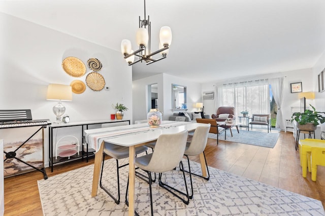 1331 S Finley Rd Unit 114, Lombard, IL 60148 - dining area featuring wood finished floors, a wall mounted air conditioner, and a chandelier