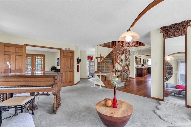 4008 Pinecrest Dr, Champaign, IL 61822 - carpeted living room with french doors, stairs, arched walkways, and a textured ceiling