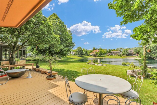4008 Pinecrest Dr, Champaign, IL 61822 - wooden deck featuring a water view, outdoor dining space, and a lawn