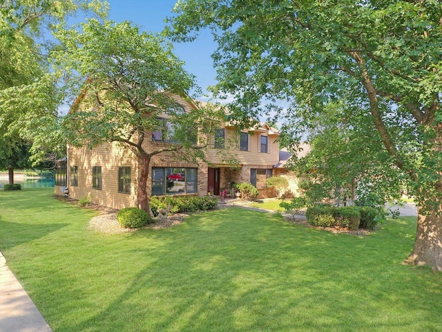 4008 Pinecrest Dr, Champaign, IL 61822 - view of front of house with a front yard, brick siding, and a water view