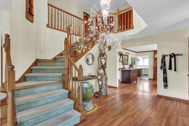4008 Pinecrest Dr, Champaign, IL 61822 - staircase featuring wood finished floors, a chandelier, baseboards, and a towering ceiling