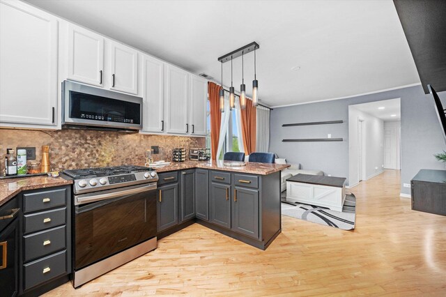 1637 W Columbia Ave Unit 3W, Chicago, IL 60626 - kitchen featuring appliances with stainless steel finishes, light wood-type flooring, white cabinetry, a peninsula, and tasteful backsplash
