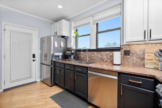 1637 W Columbia Ave Unit 3W, Chicago, IL 60626 - kitchen featuring appliances with stainless steel finishes, a sink, light wood finished floors, crown molding, and backsplash