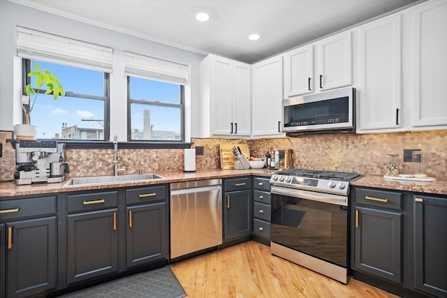 1637 W Columbia Ave Unit 3W, Chicago, IL 60626 - kitchen with appliances with stainless steel finishes, a sink, white cabinetry, light wood-type flooring, and tasteful backsplash