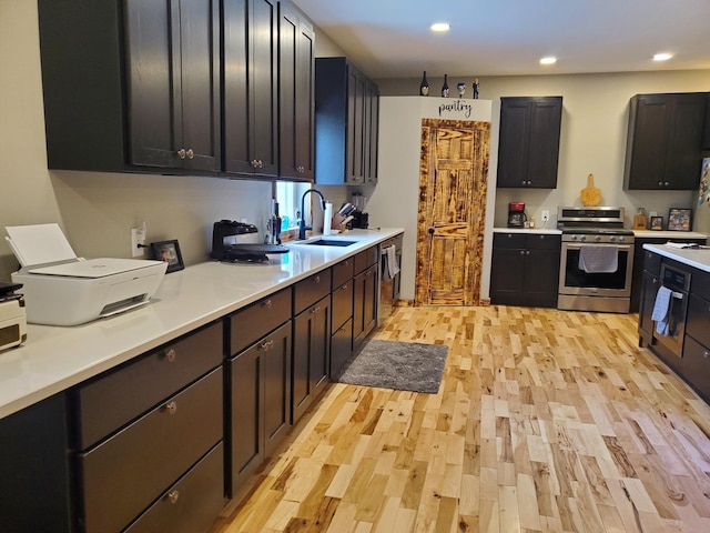 507 N Secor St, Gilman, IL 60938 - kitchen with stainless steel range, a sink, light wood-style floors, light countertops, and recessed lighting