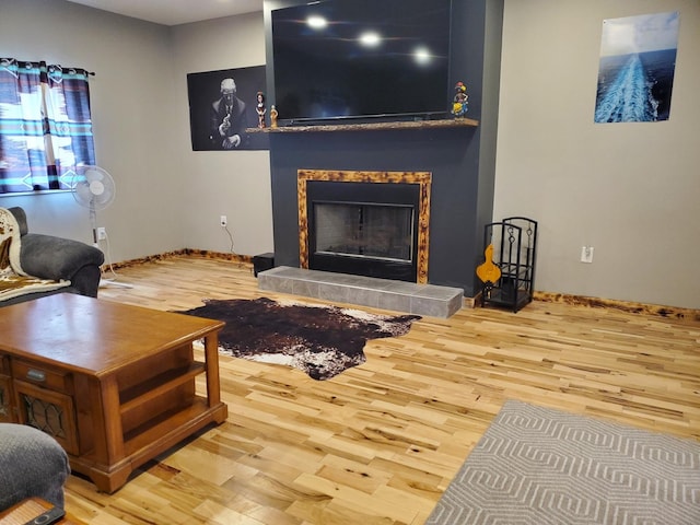 507 N Secor St, Gilman, IL 60938 - living area with wood finished floors, a tiled fireplace, and baseboards