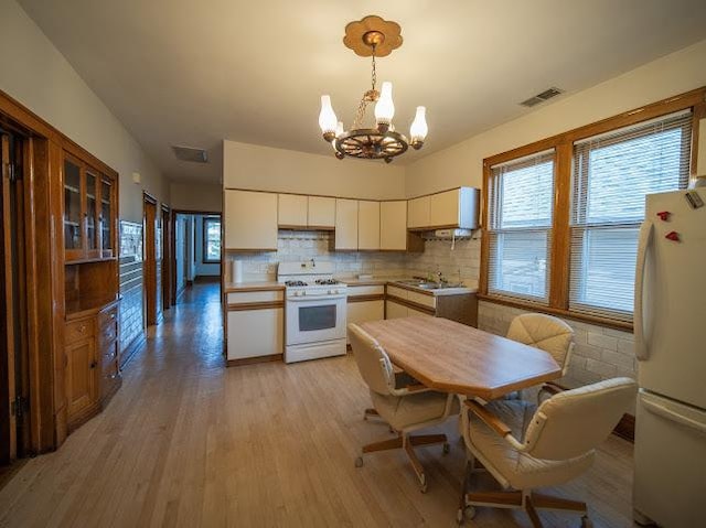 4912 S Komensky Ave, Chicago, IL 60632 - kitchen featuring white appliances, a chandelier, white cabinets, light wood-style flooring, and backsplash