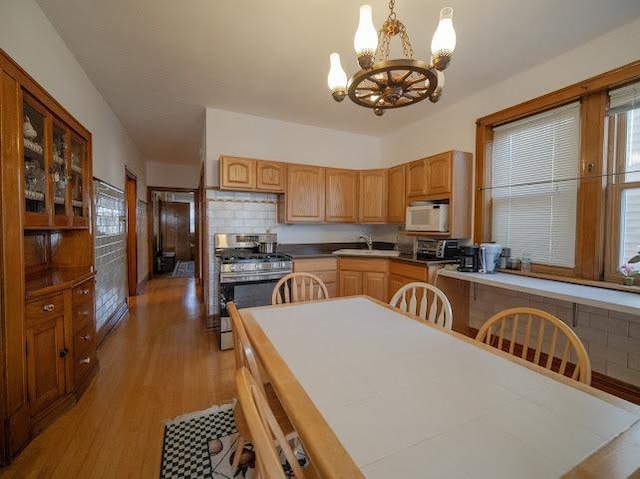 4912 S Komensky Ave, Chicago, IL 60632 - kitchen with gas stove, white microwave, a sink, a chandelier, and light wood-type flooring