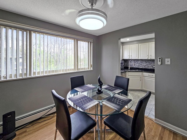 2024 W 111th St Unit 3N, Chicago, IL 60643 - dining space featuring baseboard heating, a textured ceiling, light wood-type flooring, and baseboards