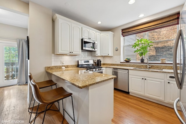 1621 W Rascher Ave Unit 2, Chicago, IL 60640 - kitchen featuring appliances with stainless steel finishes, a sink, a breakfast bar, healthy amount of natural light, and recessed lighting