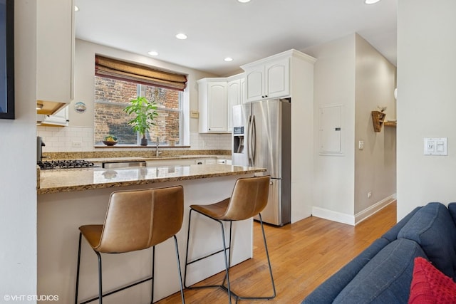 1621 W Rascher Ave Unit 2, Chicago, IL 60640 - kitchen featuring appliances with stainless steel finishes, a kitchen breakfast bar, a peninsula, white cabinets, and open floor plan