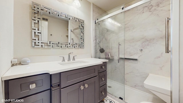 full bathroom featuring a marble finish shower and vanity