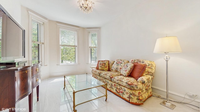 tiled living area with a chandelier and baseboards