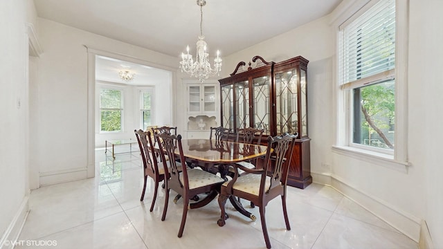 dining room featuring a chandelier, light tile patterned flooring, and baseboards