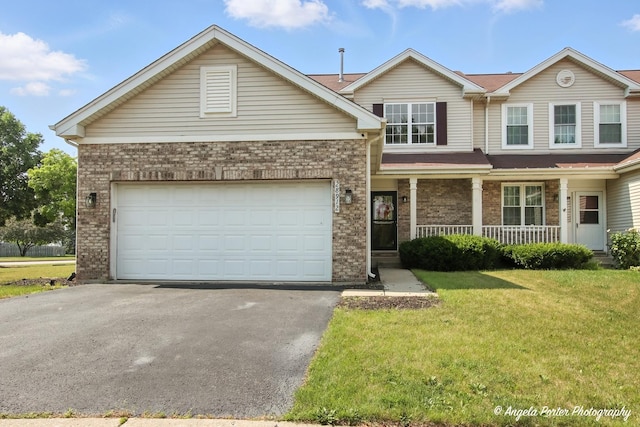 28912 Sawmill Ln, Lakemoor, IL 60051 - view of front of house with asphalt driveway, a porch, a front yard, brick siding, and a garage