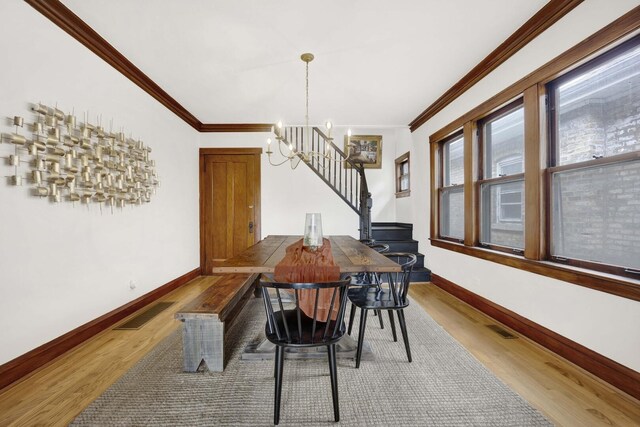 5912 W Grace St, Chicago, IL 60634 - dining area featuring a chandelier, wood finished floors, ornamental molding, baseboards, and stairs