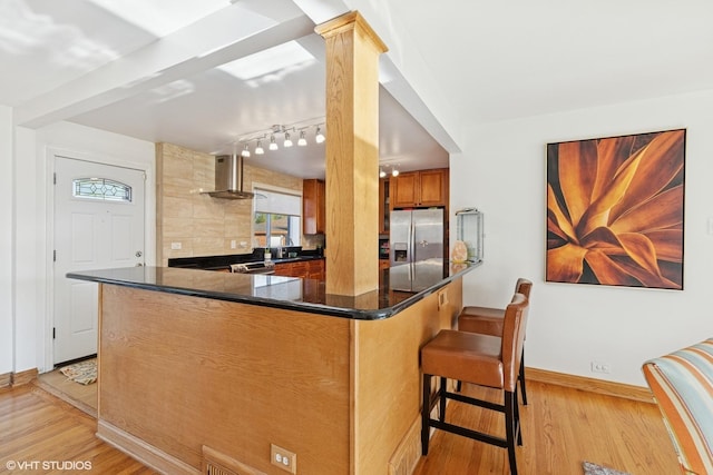9351 Kostner Ave, Skokie, IL 60076 - kitchen featuring stainless steel fridge, wall chimney exhaust hood, light wood-style flooring, baseboards, and a sink