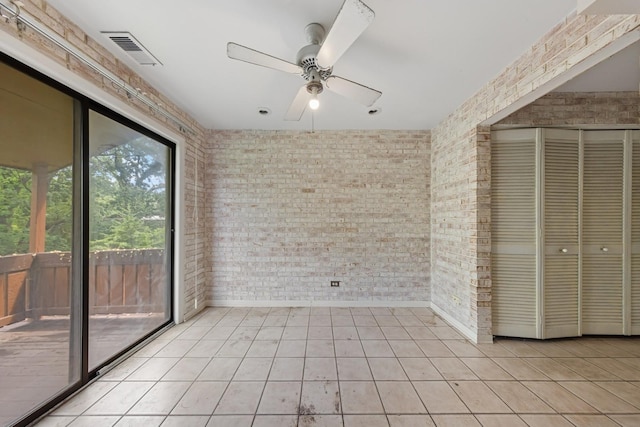 1S055 Spring Rd Unit 2B, Oakbrook Terrace, IL 60181 - unfurnished bedroom featuring brick wall, access to outside, light tile patterned floors, a closet, and ceiling fan
