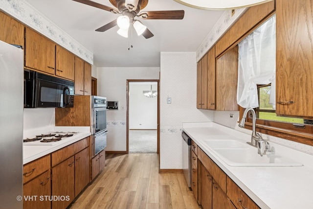 452 Miller St, Beecher, IL 60401 - kitchen with wallpapered walls, appliances with stainless steel finishes, light wood-style floors, a sink, and brown cabinets