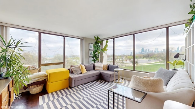 sunroom / solarium with healthy amount of natural light, a view of city, wood finished floors, and outdoor lounge area