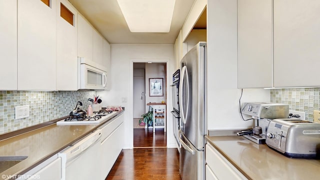 kitchen featuring white appliances, white cabinetry, dark wood-style floors, decorative backsplash, and light countertops
