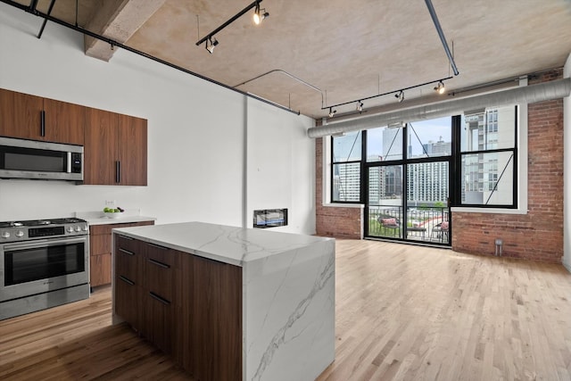 kitchen with stainless steel appliances, track lighting, light wood-style floors, open floor plan, and modern cabinets