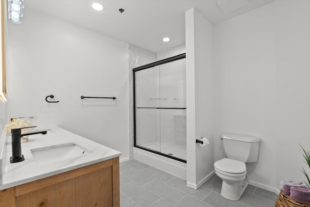 bathroom with a sink, toilet, a shower stall, baseboards, and recessed lighting