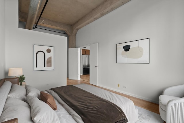 bedroom with light wood-type flooring and beamed ceiling